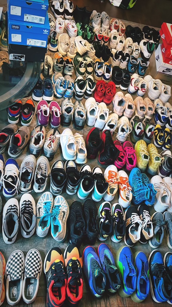Dozens of pairs of sneakers laid out in rows on the floor, sorted and ready to hand out.